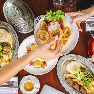 Enjoy a vibrant meal setting at a Dubai restaurant featuring diverse dishes and lively atmosphere.