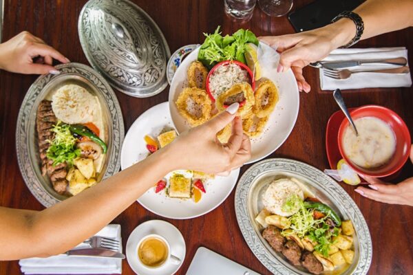 Enjoy a vibrant meal setting at a Dubai restaurant featuring diverse dishes and lively atmosphere.